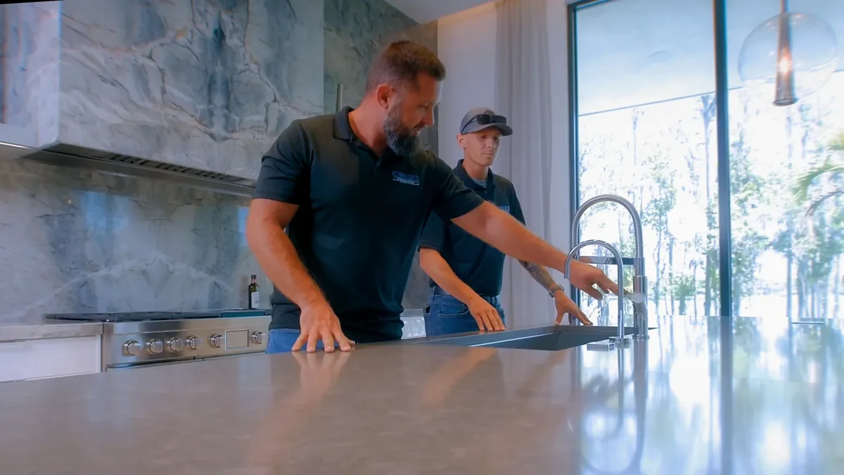 Crego Contracting crew checking a new stone countertop and undermount sink during a kitchen remodel, serving Hudson, FL